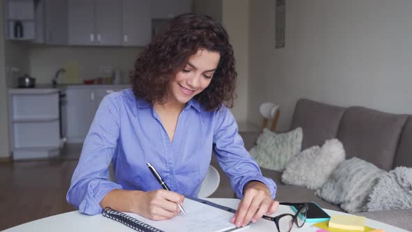 Portrait of Happy Latin Young Female Student Studying at Home Looking at Camera