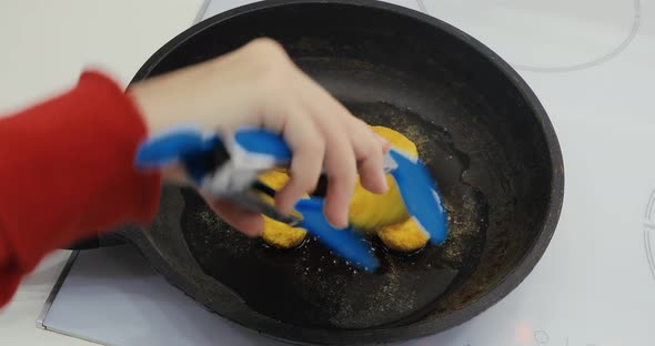 A Girl Cooks Food in the Kitchen