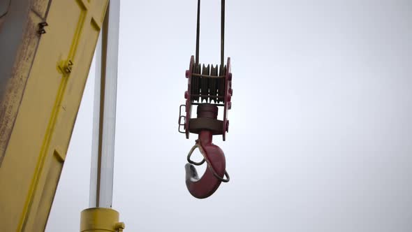 Big Hook Closeup of a Tower Crane with Cloudy Sky