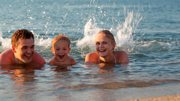 Young Family Splashing in the Sea