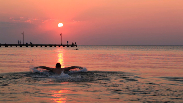 Man Swimming in the Sea at Sunset