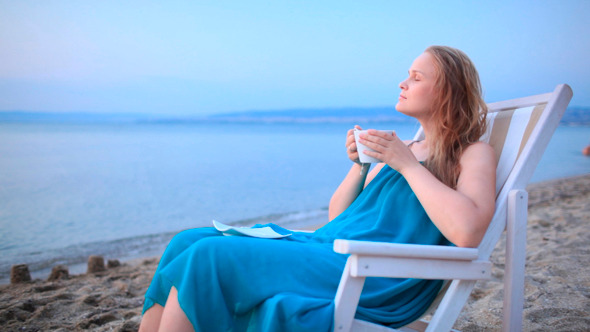 Woman Enjoying a Cup Of Tea at the Seaside