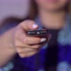 Young Woman Sits on an Armchair and Watches TV - VideoHive Item for Sale