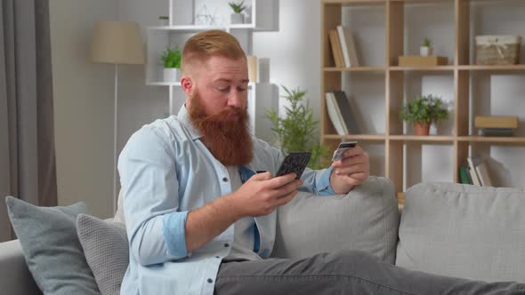 Young Bearded Redhead Man in Casual Clothing Relaxing Using Mobile Phone Smartphone Make Online