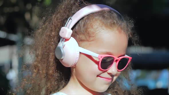 Portrait of a Cute Child, a Wonderful Little Beautiful Girl in a White Dress With Pink Glasses