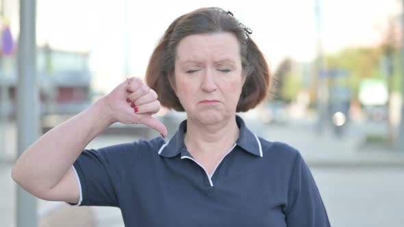 Thumbs Down By Old Woman Standing Outdoor