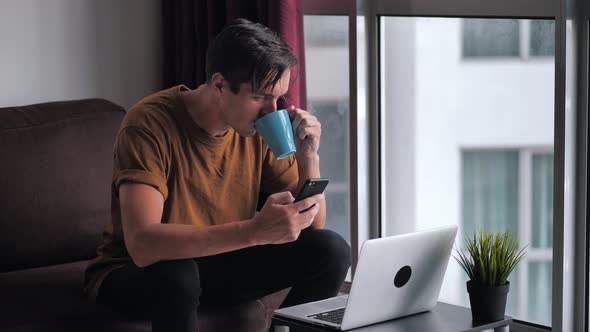 Busy Man Using Smartphone and Laptop Computer for Ecommerce Doing Online Shopping Watching Video