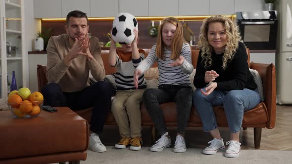 Excited Deaf Family Watching Soccer Match on TV