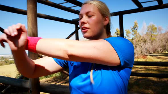 Determined woman performing stretching exercise during obstacle course