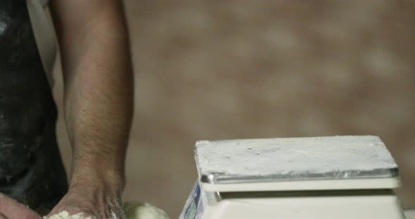 Hands Of A Baker Weighing The Kneaded Dough On A Baking Scale In The Bakery.  - close up shot