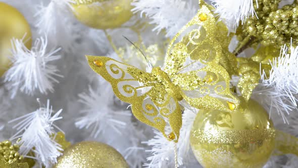 Detail of a beautiful white Christmas tree festooned with golden butterfly and balls. Panoramic plan