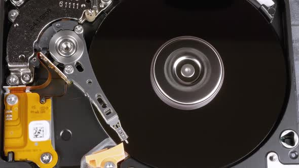 Opened Hard Disk Drive with Spinning Platter. Move of Writing Magnetic Head