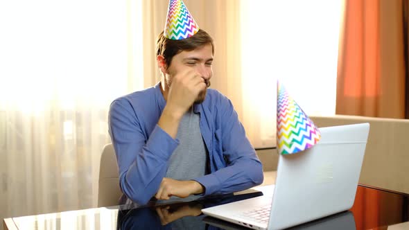 Man Sits in Front of a Laptop Celebrates Birthday