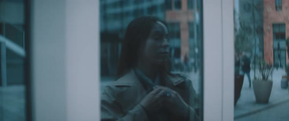 Woman looks at reflection in shop window