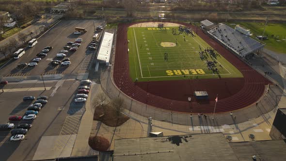 Athletes running around track in Roosevelt High School, aerial orbit view