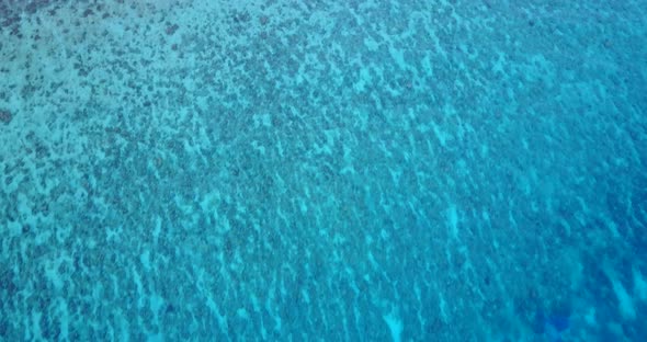 Wide fly over island view of a summer white paradise sand beach and aqua blue water background