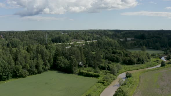 Slow aerial pan of the countryside in Kerava, Finland with a motorway and old stone bridge.