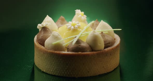 Shot of Sweet Round Dessert with White Brown Cream on Green Background