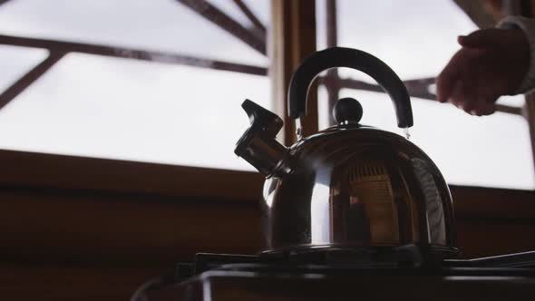 Caucasian hand man spending time at home, taking a kettle