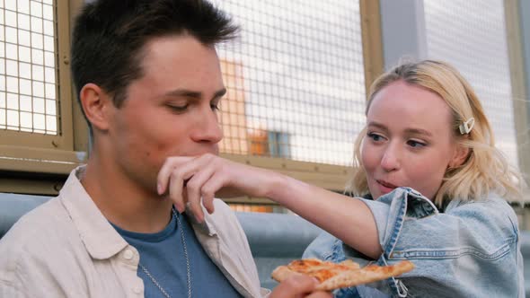 Happy Couple Eating Pizza on City Street