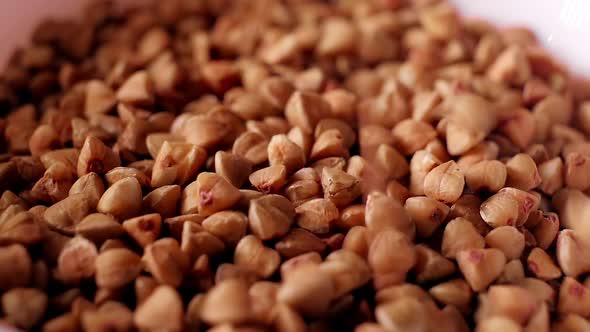 A Pile of Raw Buckwheat Falls in Slow Motion