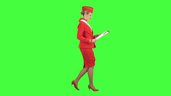 Woman Steps Along with a Red Folder in Her Hands. Green Screen. Side View