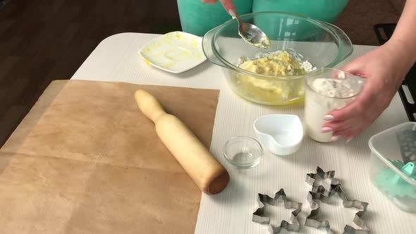 A Woman Mixes The Ingredients For Making A Biscuit In A Container.