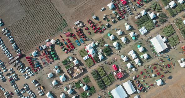 Drone Shot with Descending and Turning Top View of Agricultural Expo Fair on Yellow Fields of Farm L