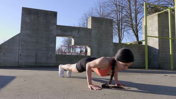 Athletic Hispanic Woman doing pushups outdoors, Slow Circle Pan Right