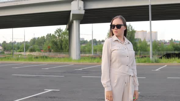 Beautiful Young Girl with Glasses Walks Through the City and Looks Around