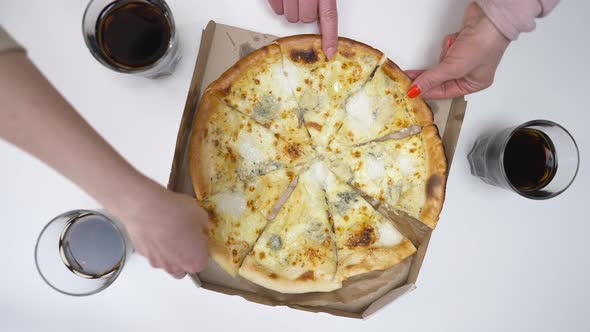 Top View Tasty Pizza on Table with Female Caucasian Hands Taking Slices Leaving