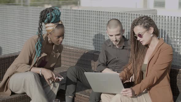 Business People Looking at Laptop Screen During Outdoor Party