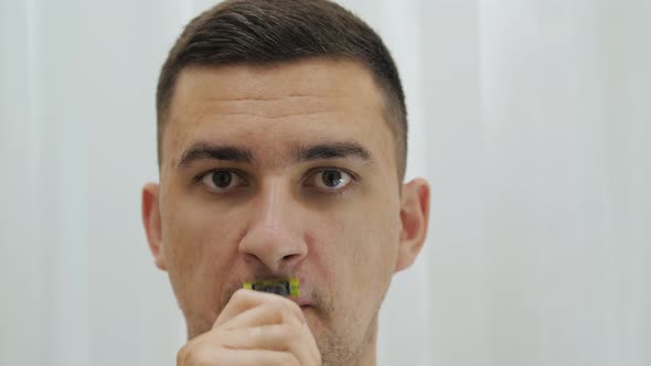 Close Up Handsome Man Is Shaving Beard and Moustache Using Electric Razor.