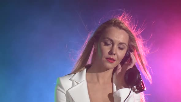 Beautiful, Charming, Dj Girl in White Jacket, Using One Part of Headphones on Her Ears, Listening