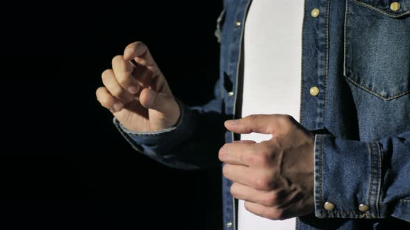 Closeup of the Hands of a Young Male Business Coach Speaking Passionately From the Stage in a Dark