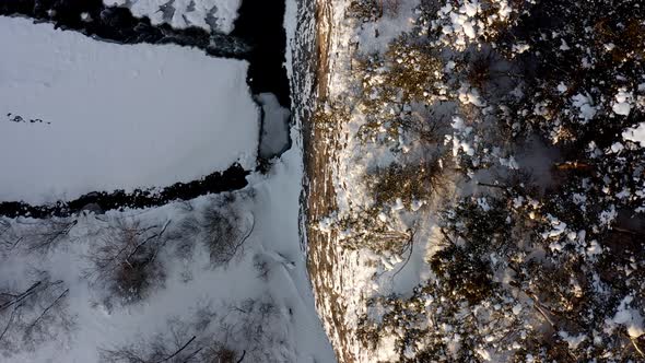 Trees On Top Of Cliff With Snowy Stream Below At Wintertime Near Bialka Tatrzanska, Poland. - aerial