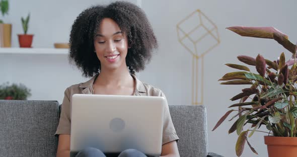 Afro American Girl Sits at Home in Quarantine Room, Communicates with Friends Remotely Online in