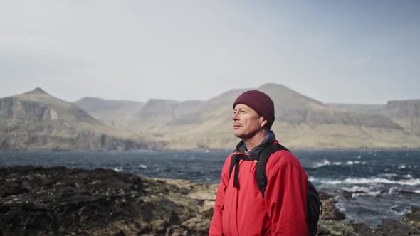 Man Looking Upwards Enjoying the Cold Sunny Breeze in Faroe Islands