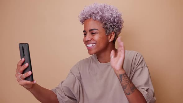 Young Happy African American Woman Looking at Phone Doing Video Blogging