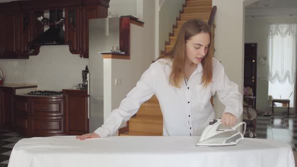 Pretty Caucasian Young Woman Dancing While Doing Housework at Home
