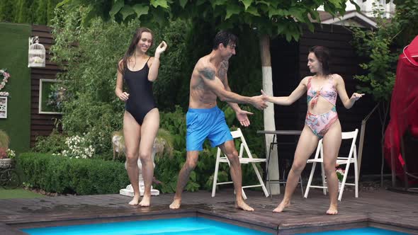 Joyful Carefree Middle Eastern Man and Caucasian Women Dancing at Poolside Outdoors in Slow Motion