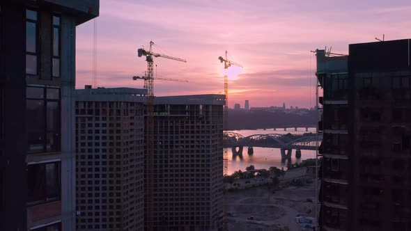 Aerial Vertical Flight Over Construction Site in City at Sunset