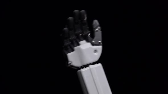 Hand of a Robot Close Up Waving Hello . Black Background