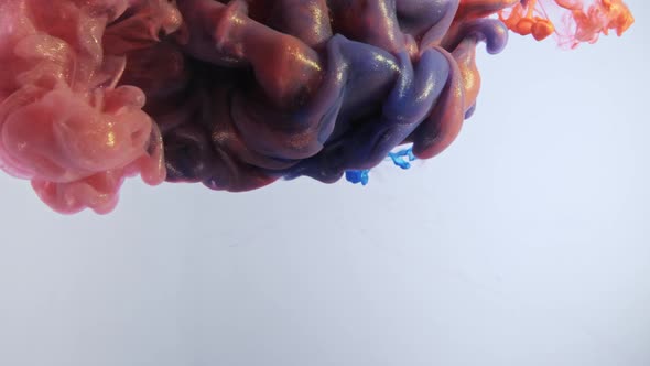 Colorful Nacreous Paint in Water Against White Background. alt