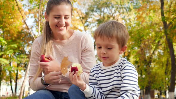 Video of 4 Years Old Little Boy Eating Apple and Giving Yellow Tree Leaves To His Mother at Autumn