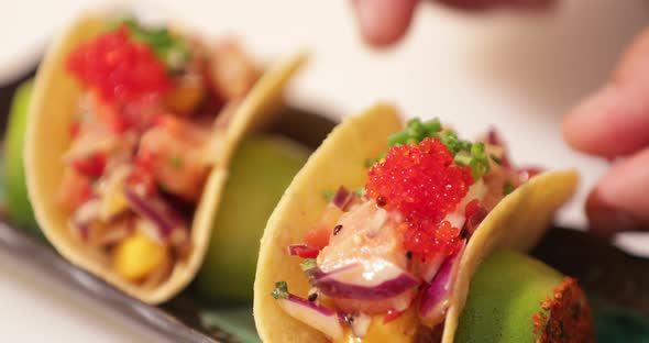 Food Plating - Chef's Hand Arranging The Sushi Tacos On The Plate For Serving. - close up shot