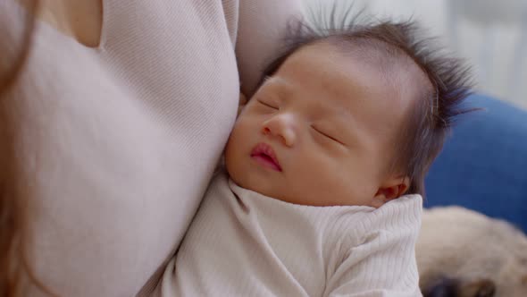 Adorable sleeping newborn baby relax in mother arm safety and comfortable