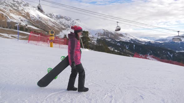 Girl Snowboarder with Snowboard on Mountain Top on Ski Resort. Winter Sports and Winter Vacation