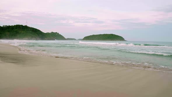 Ocean waves breaking into the shore on the beach in Phuket, Thailand.