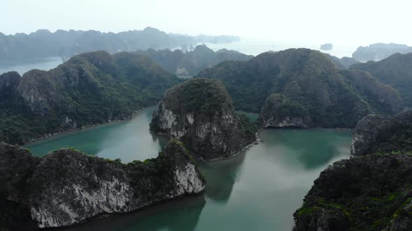 Aerial: flying over Ha Long Bay rock pinnacles, famous tourism destination in Vietnam